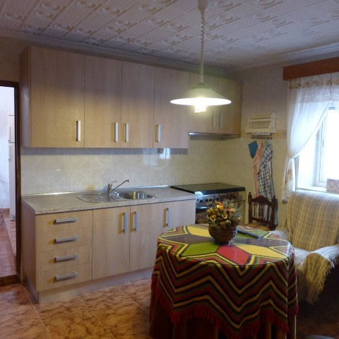 Bright kitchen with wooden cabinets and modern appliances in Fontanar, Jaen.