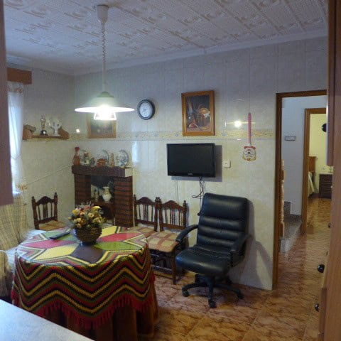 Charming living room with dining area, fireplace, and modern TV in a traditional Fontanar home.
