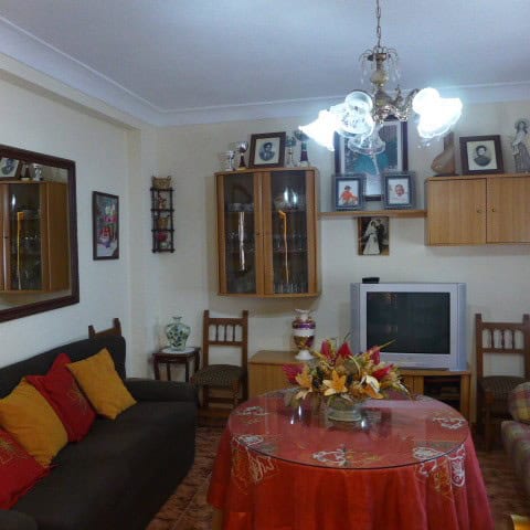 Cozy living room with traditional decor in a town house located in Fontanar, Jaen. Features a sofa,.