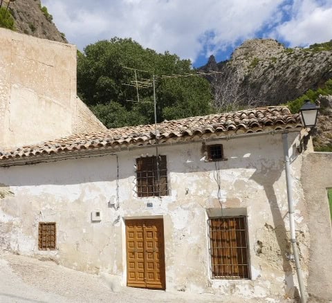 Traditional rural property in Don Pedro, Jaen, featuring rustic walls and wooden window bars.