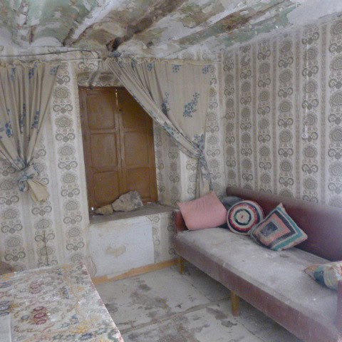 Vintage interior with worn furniture and traditional decor.