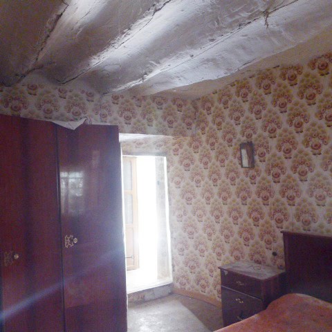 Charming rural home interior with vintage wallpaper and natural light from the window.