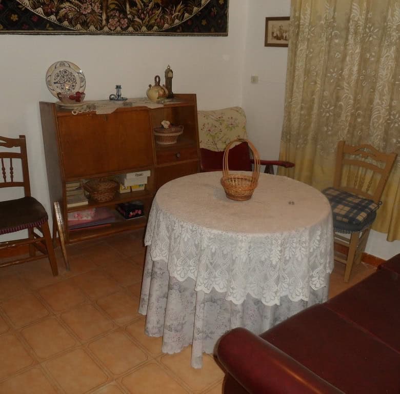 Charming cave house interior in Freila, Granada, featuring a cozy dining area with vintage furniture.