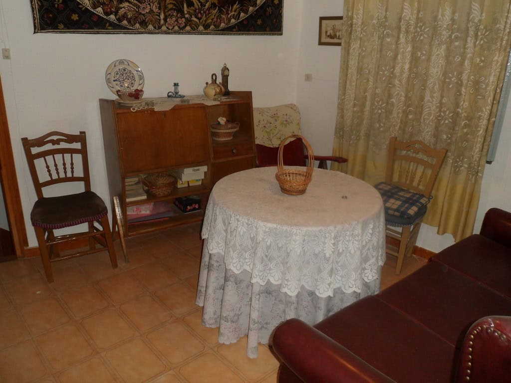 Charming cave house interior in Freila, Granada, featuring a cozy dining area with vintage furniture.