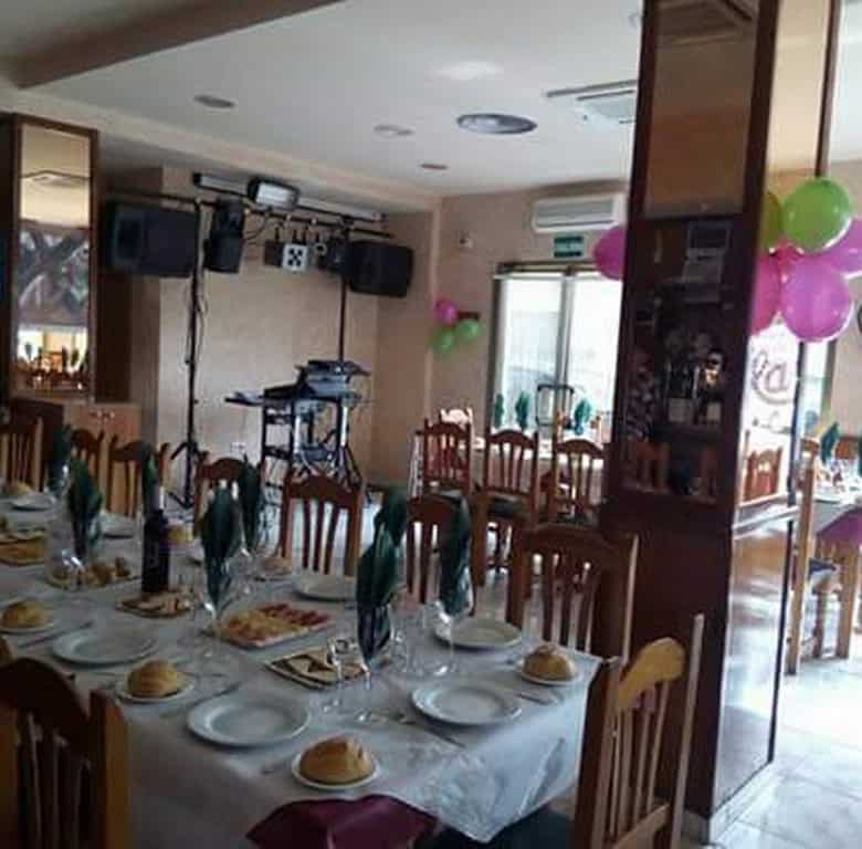 Spacious indoor dining area with decorated tables, chairs, and balloons for celebrations in Cuevas d.