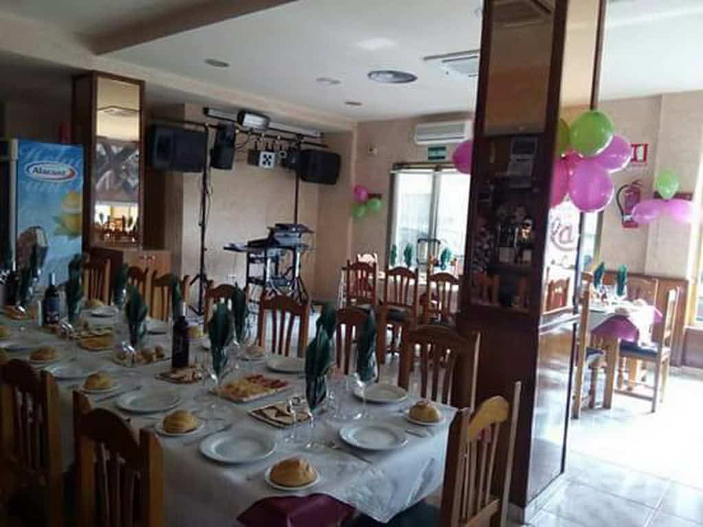Spacious indoor dining area with decorated tables, chairs, and balloons for celebrations in Cuevas d.