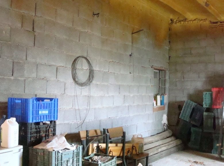 Interior view of a rustic rural property in Hijate, Almeria, showing unfinished walls and storage cr.