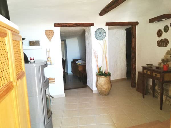 Cave house interior in Galera, Granada, featuring rustic wooden beams and traditional decor.
