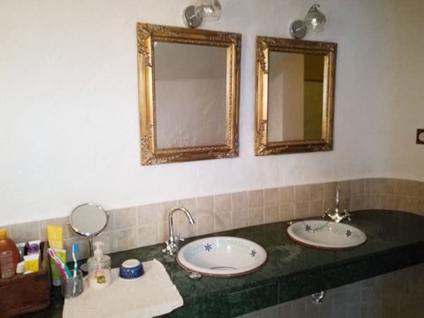 Cave house interior with dual sinks and mirrors in Galera, Granada. Unique rustic home in a scenic r.
