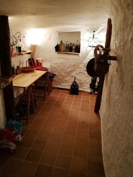 Cozy interior of a traditional cave house in Galera, Granada, featuring rustic decor and unique arch.
