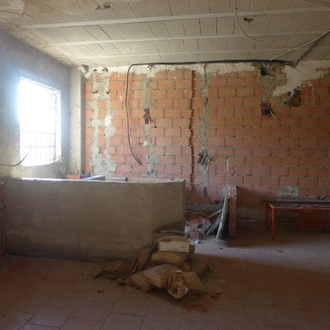 Interior view of a partially finished town house in Castril, Granada, showing exposed brick walls an.