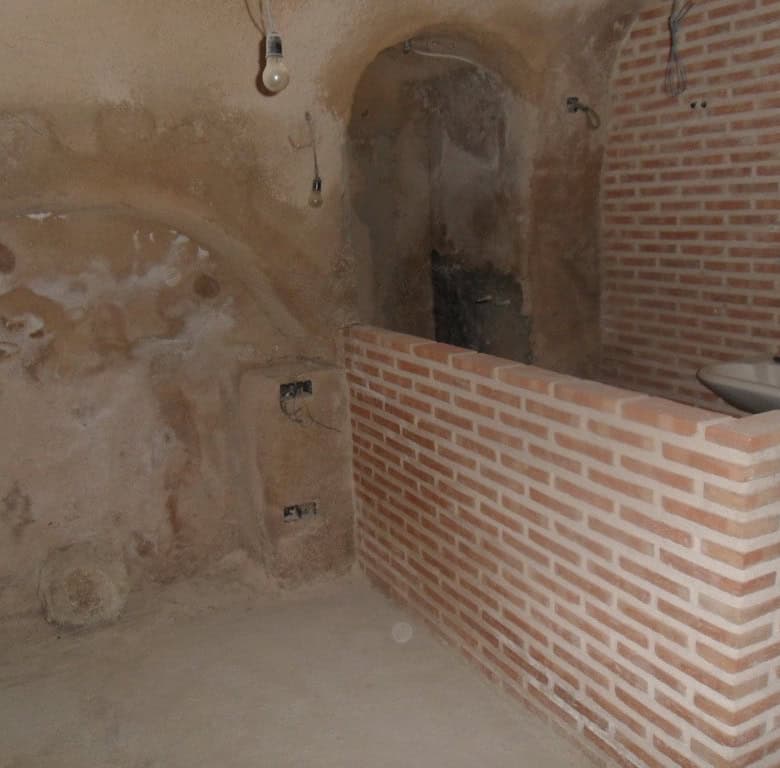 Cave house interior with brick partition and rustic walls in Cuevas del Campo, Granada.