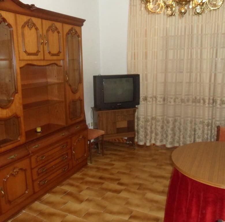 Cave house interior in Freila, Granada with vintage furniture and a small TV.