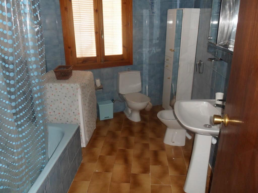 Charming cave house interior in Freila, Granada, featuring a bathroom with a toilet, sink, and showe.