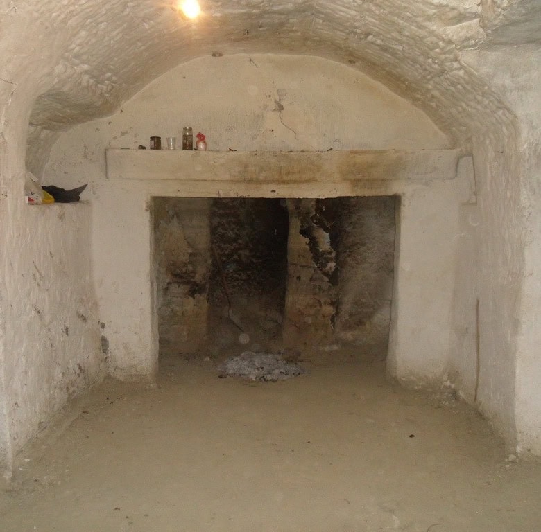 Cave house interior with rustic stone walls and arched ceiling in Benamaurel, Granada.