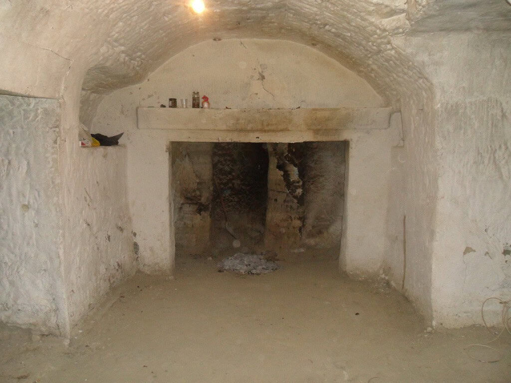 Cave house interior with rustic stone walls and arched ceiling in Benamaurel, Granada.
