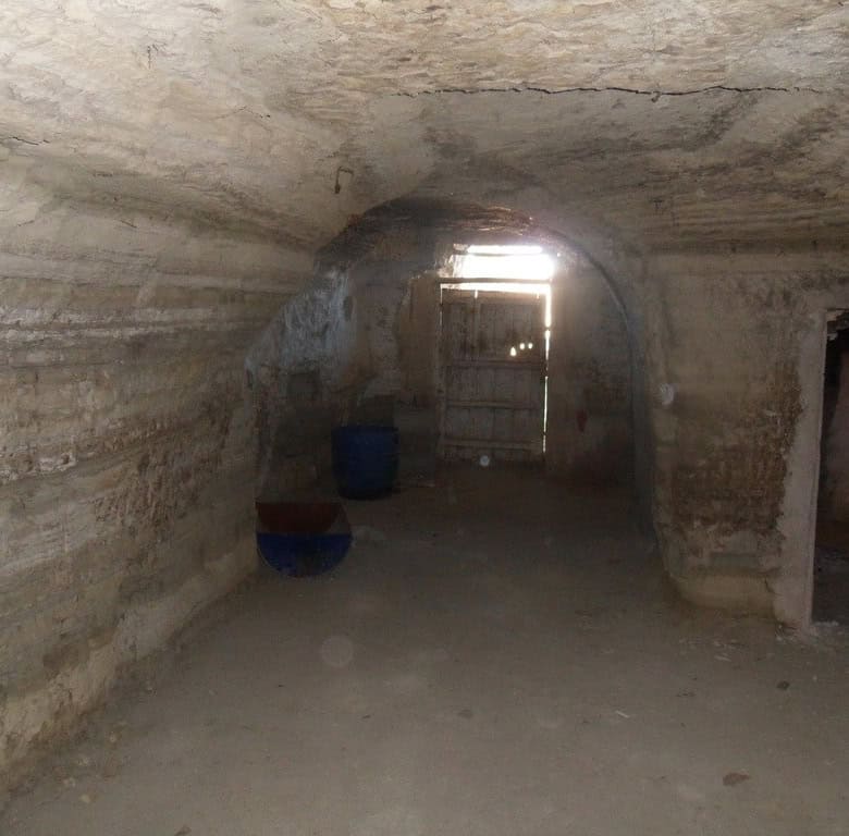 Cave house interior in Benamaurel, Granada, showcasing natural rock walls and rustic charm.