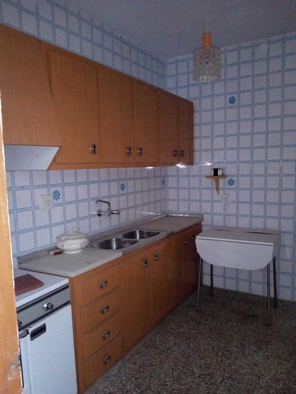 Charming kitchen in Tijola town house with wooden cabinets and tiled walls, perfect for comfortable.