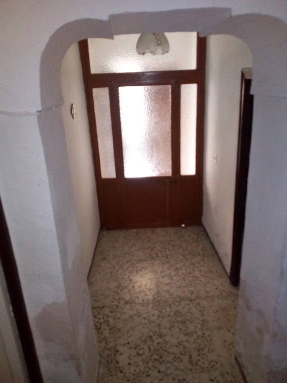 Entrance door of a town house in Tijola, Almeria, showing a wooden door with frosted glass panels.