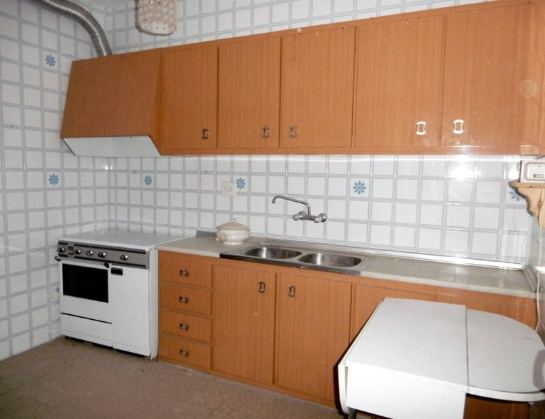 Kitchen of a town house in Tijola, Almeria, featuring wooden cabinets and basic appliances.