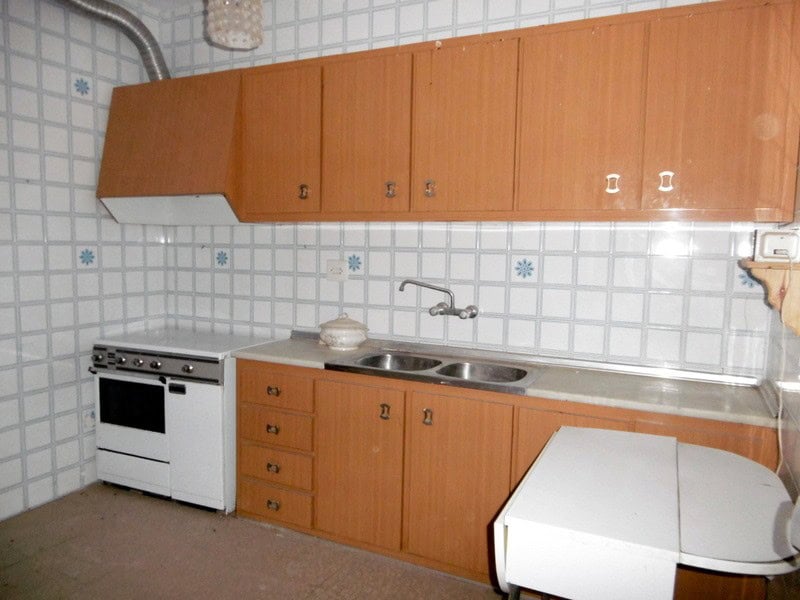 Kitchen of a town house in Tijola, Almeria, featuring wooden cabinets and basic appliances.