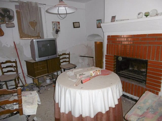 Charming town house living room with fireplace, vintage furniture, and rustic decor in Tijola, Almer.