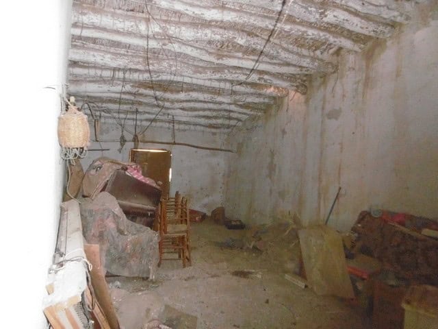 Interior of a rustic town house in Tijola, Almeria, showing unfinished walls and ceiling with constr.