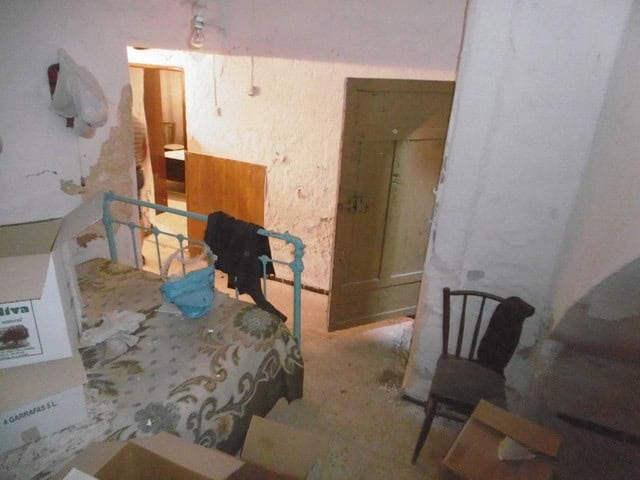 Cozy interior of a town house in Tijola, Almeria, featuring rustic walls and simple furnishings.