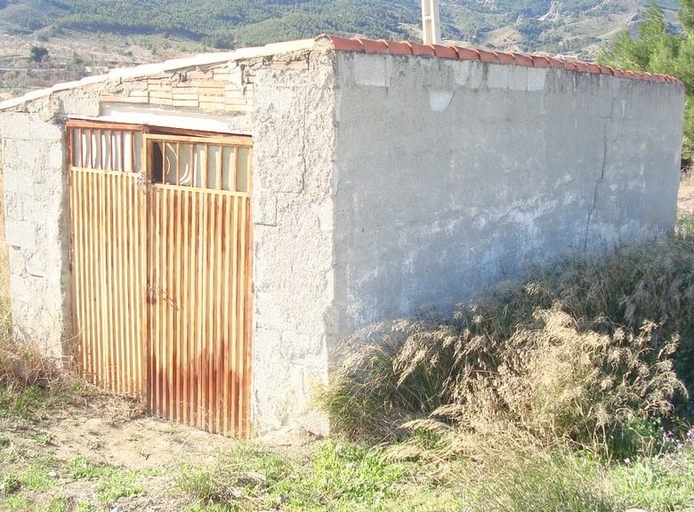 Land in Tijola, Almeria with rustic building and scenic mountain views.