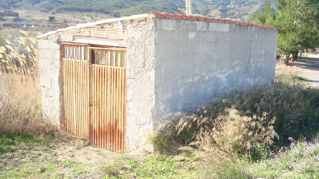 Land in Tijola, Almeria with rustic building and scenic mountain views.