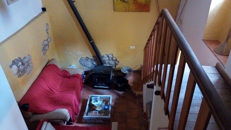Interior view of a town house in Quesada, Jaen, showing a living room with a red sofa and staircase.
