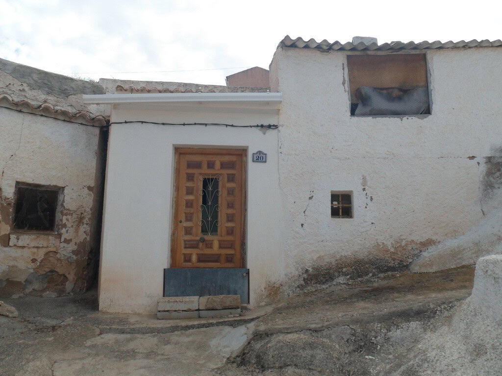 Cave house in Freila, Granada, featuring rustic architecture and unique hillside location.