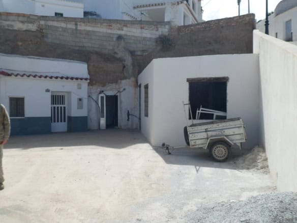 Cave house in Freila, Granada with white walls and rustic surroundings.