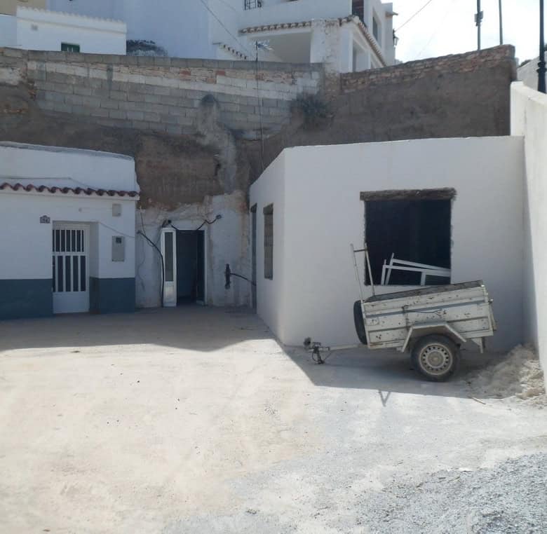 Cave house in Freila, Granada with white walls and rustic surroundings.