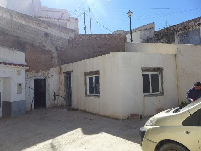 Cave house in Freila, Granada, with white exterior walls and small windows, set in a rural area with.