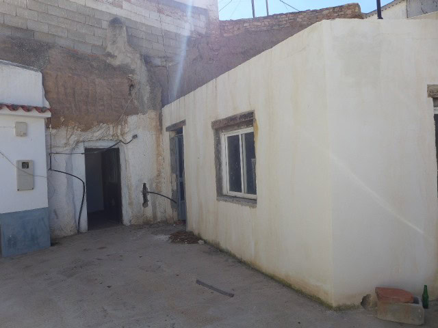 Cave house in Freila, Granada, with simple exterior walls and small windows, set in a rustic rural e.