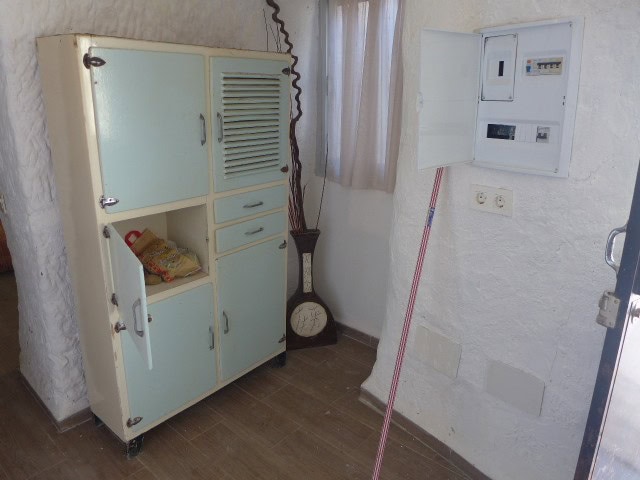 Cave house interior with electrical panel and vintage decor in Freila, Granada.
