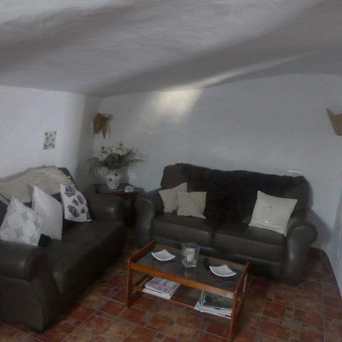 Charming cave house living room in Galera, Granada with rustic decor and comfortable seating.