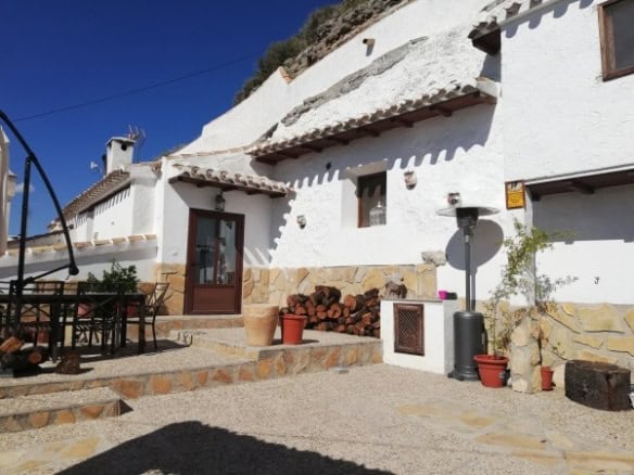 Unique cave house for sale in Galera, Granada, with traditional whitewashed exterior and rustic outd.