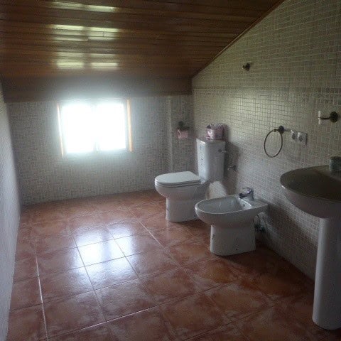 Castril town house bathroom with natural light, toilet, bidet, and sink.