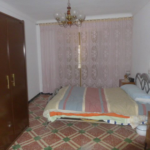 Charming bedroom in Castril town house, Granada, with vintage decor and natural light.