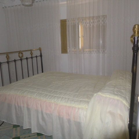 Cozy bedroom in a town house located in Castril, Granada, featuring a metal bed frame and simple dec.