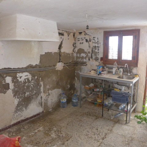 Old kitchen space in a town house in Cullar, Granada, showing unfinished walls and basic fixtures.