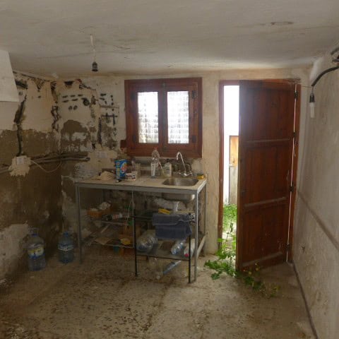 Interior view of a rustic town house kitchen in Cullar, Granada, with simple furnishings and natural.