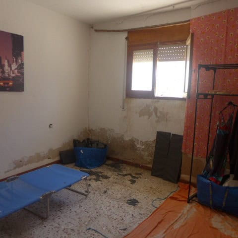 Cozy interior of a town house in Cullar, Granada, showing a small room with a window, some furniture.