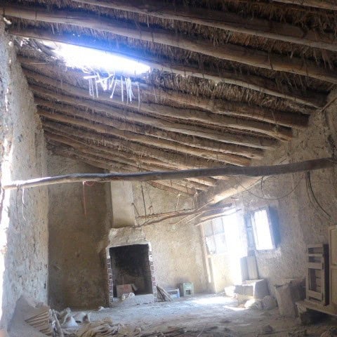 Interior view of a rustic town house in Cullar, Granada, showing a traditional thatched roof and unf.