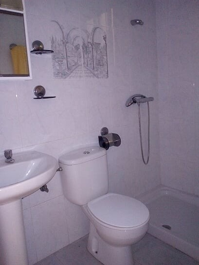 Cozy bathroom in a village property in Tijola, Almeria, featuring a toilet, sink, and shower area.