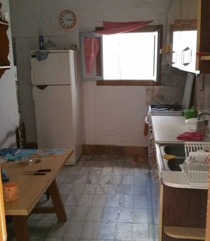 Village Property Kitchen with Refrigerator and Window View.