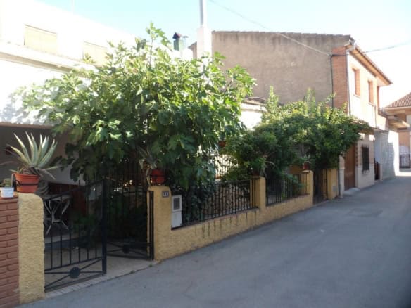 Village property in Zujar, Granada with lush greenery and traditional architecture.