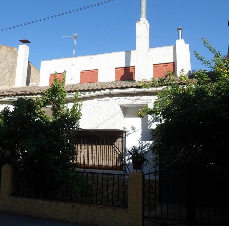 Village property in Zujar, Granada with traditional architecture and lush greenery.